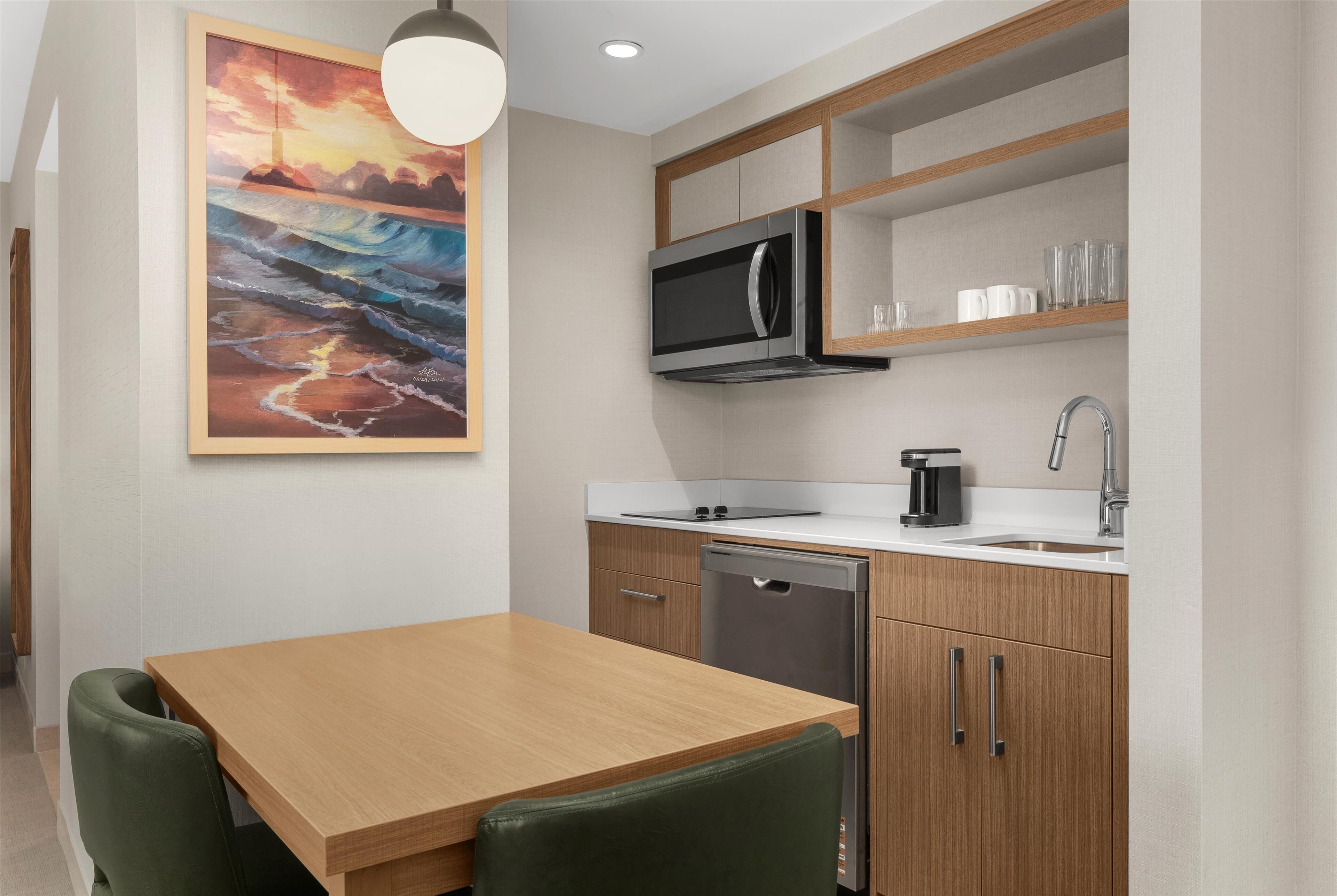 A modern kitchen with wooden cabinets, a microwave, and a coffee maker.