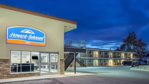 Een Howard Johnson Inn met een opvallend bord, een zichtbare ingang en een parkeerplaats.