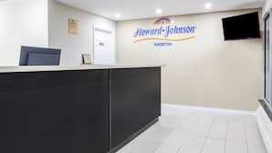 Een receptiegedeelte met een receptiebalie, een ingelijst diploma en een wandbordje voor Howard Johnson in Kingston.