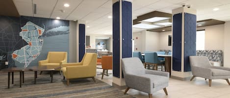 A lobby with seating areas, a reception desk, and a map mural on the wall.