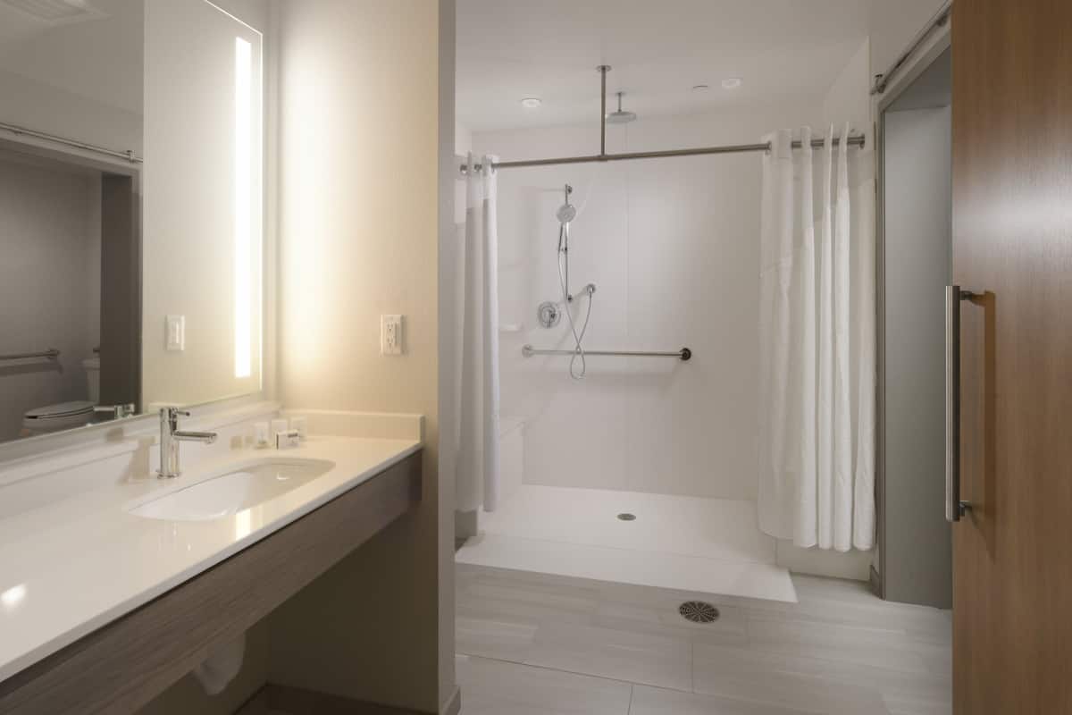 Suite, 1 King Bed, Accessible (Comms, Roll Shwr) | Bathroom | Combined shower/tub, free toiletries, hair dryer, towels