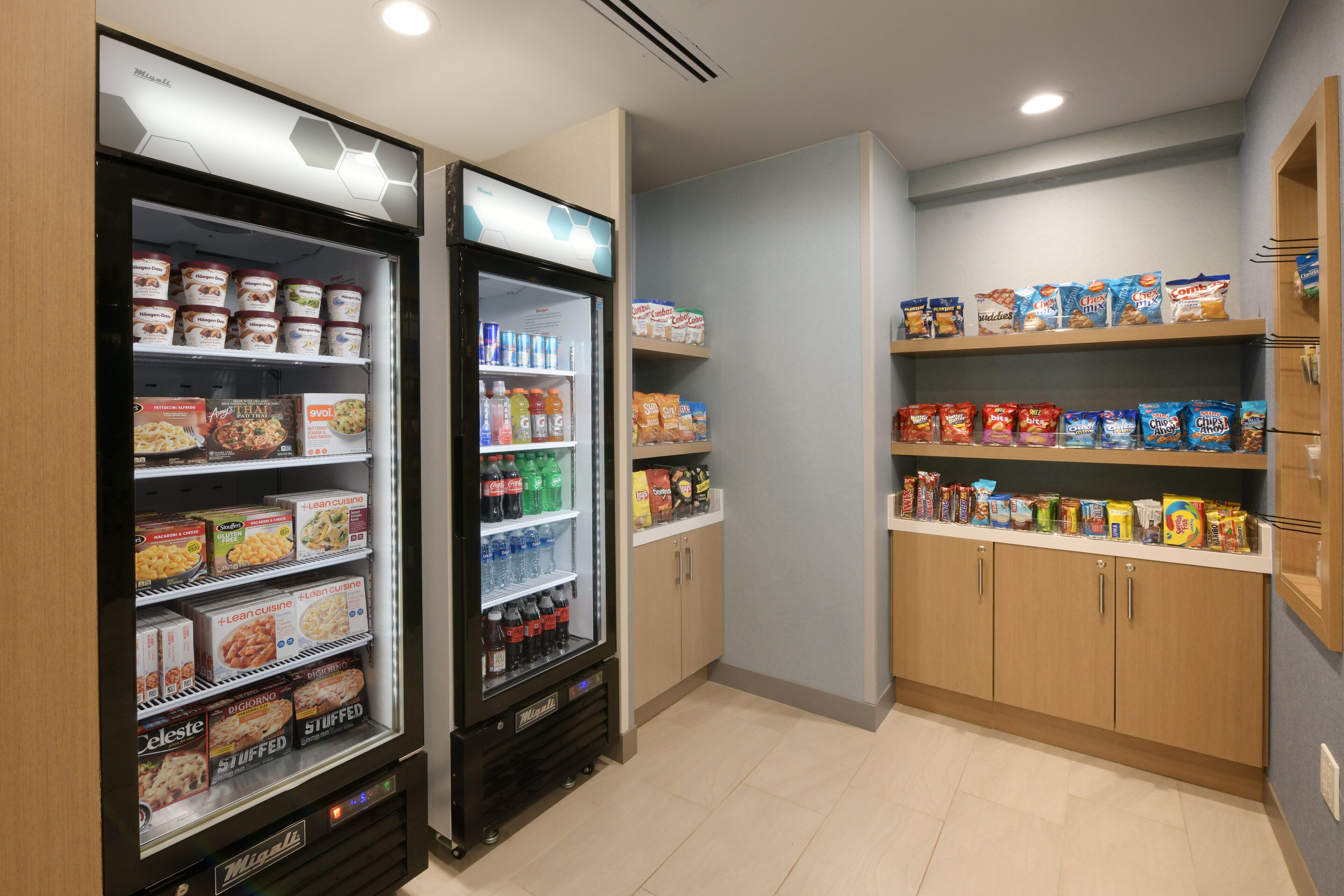 A self-service food area with refrigerated cases and shelves stocked with various food items and beverages.