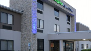 A Holiday Inn Express building with a stone facade and a green logo. - Holiday Inn Express & Suites Williamstown - Glassboro by IHG (Williamstown)