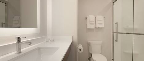 Un bagno moderno con un lavandino bianco, un water e un box doccia in vetro.