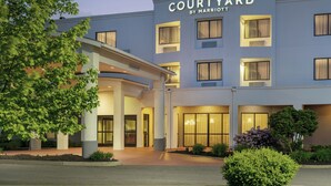 A Courtyard by Marriott hotel with a modern facade, large windows, and a well-maintained entrance area. - Courtyard by Marriott Kingston (Kingston)