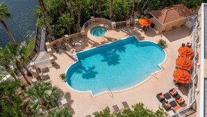 An aerial view of a resort with a large swimming pool surrounded by palm trees and lounge chairs. - Hilton St. Petersburg Carillon Park (St. Petersburg)