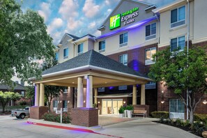 A Holiday Inn Express building with a covered entrance, brick facade, and a parking lot with a fire lane. - Holiday Inn Express Hotel & Suites Dallas-Grand Prairie I-20 by IHG (Grand Prairie)