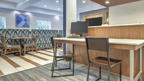 A modern hotel lobby with a reception desk, seating area, and large windows. - Holiday Inn Express Hotel & Suites Dallas-Grand Prairie I-20 by IHG (Grand Prairie)
