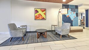 A lobby with two armchairs, a small round table, and a map mural on the wall. - Holiday Inn Express Hotel & Suites Dallas-Grand Prairie I-20 by IHG (Grand Prairie)