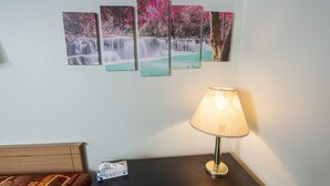 A hotel room with a bed, a nightstand with a lamp, and a wall with five framed pictures of waterfalls. - Tower 64 Motel & RV Park (Trinidad)