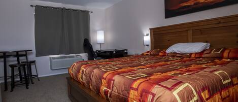 A bedroom with a large bed, a desk, and a chair.