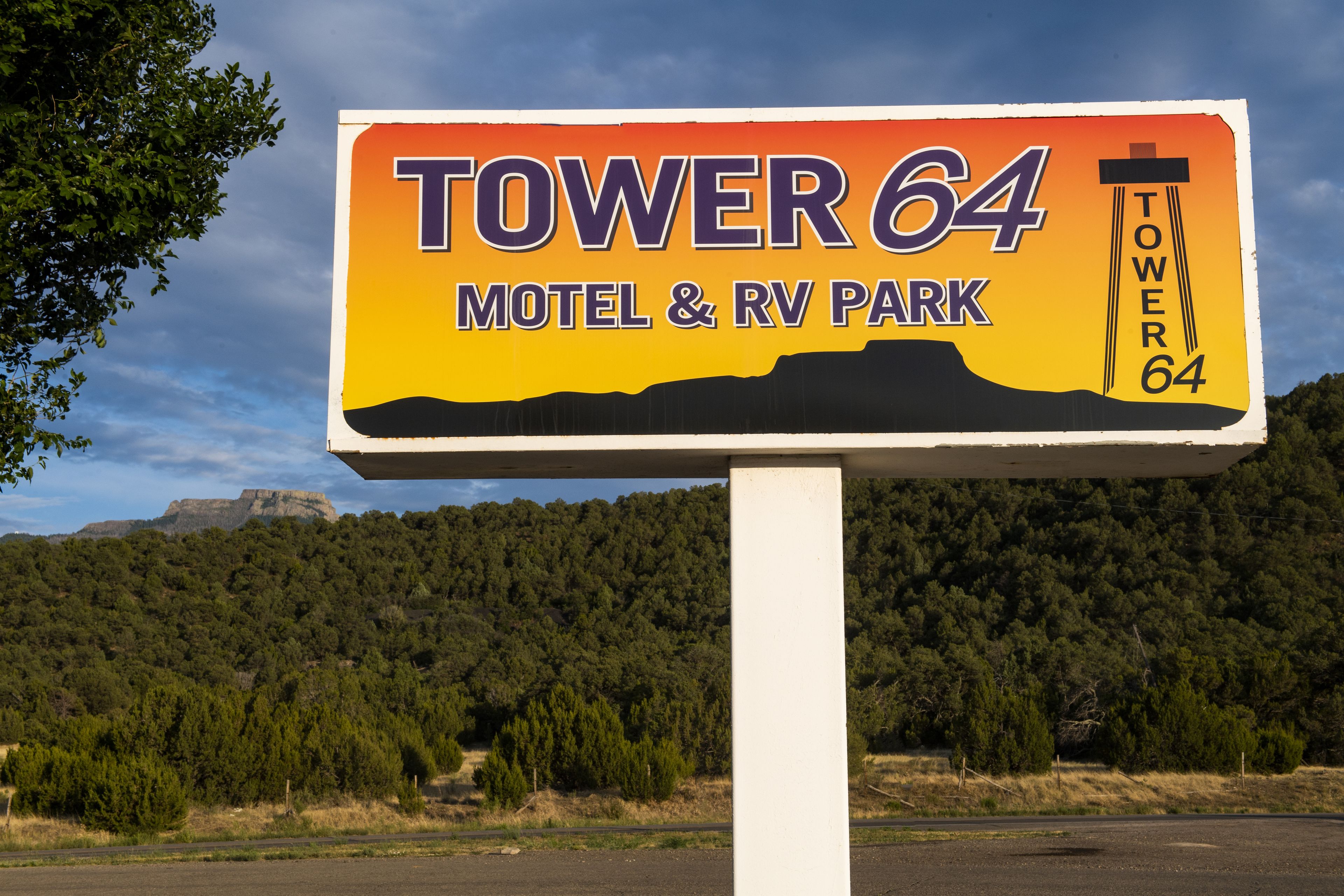 En skylt för Tower 64 Motel & RV Park, med ett berg i bakgrunden.