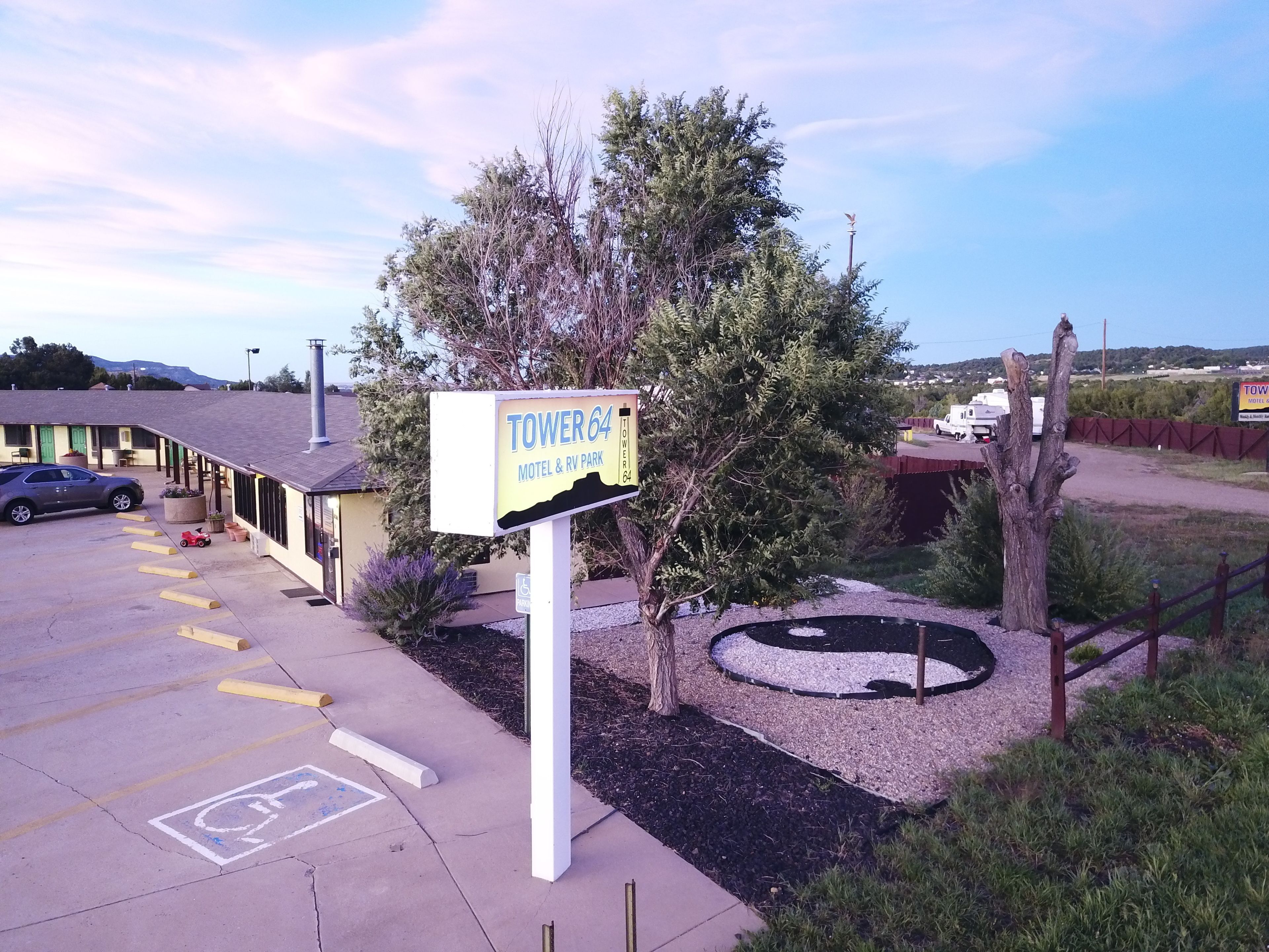 Un panneau indiquant un motel, un parking et un petit espace aménagé en jardin.