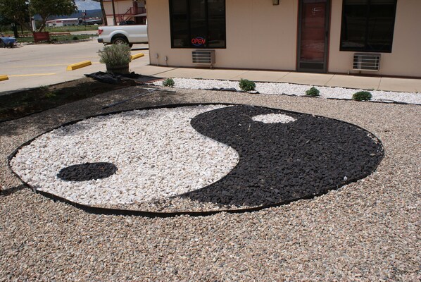 A Zen garden with a yin-yang symbol made of gravel and small plants.