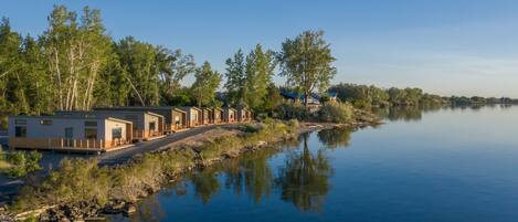 Une propriété au bord du lac, comprenant une série de chalets, un quai et une vue dégagée sur l’eau.