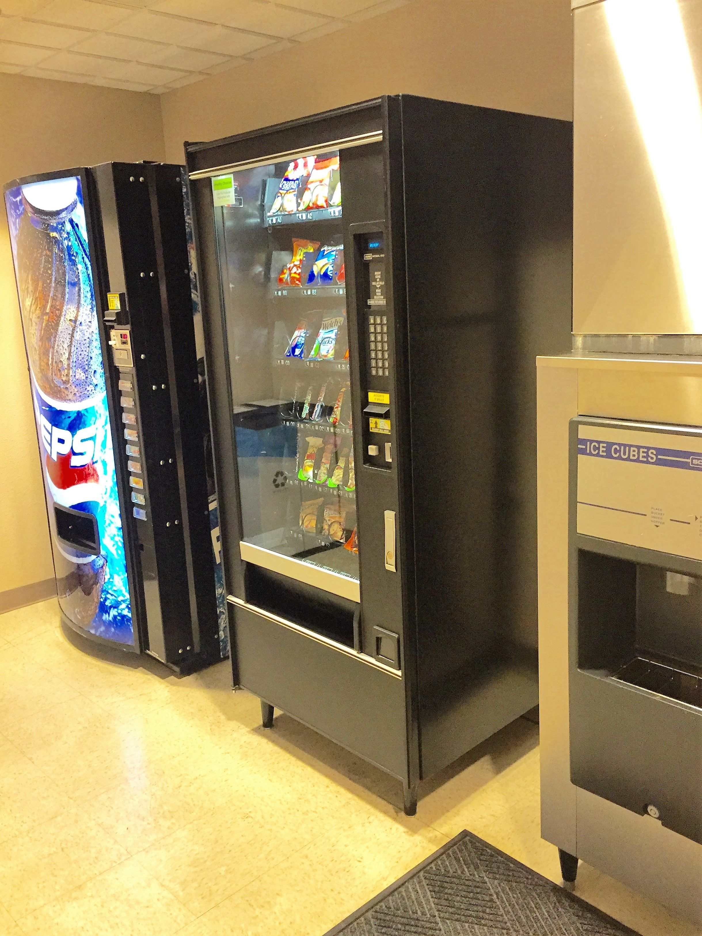 Zona de máquinas expendedoras con dispensador de Pepsi y dispensador de hielo.