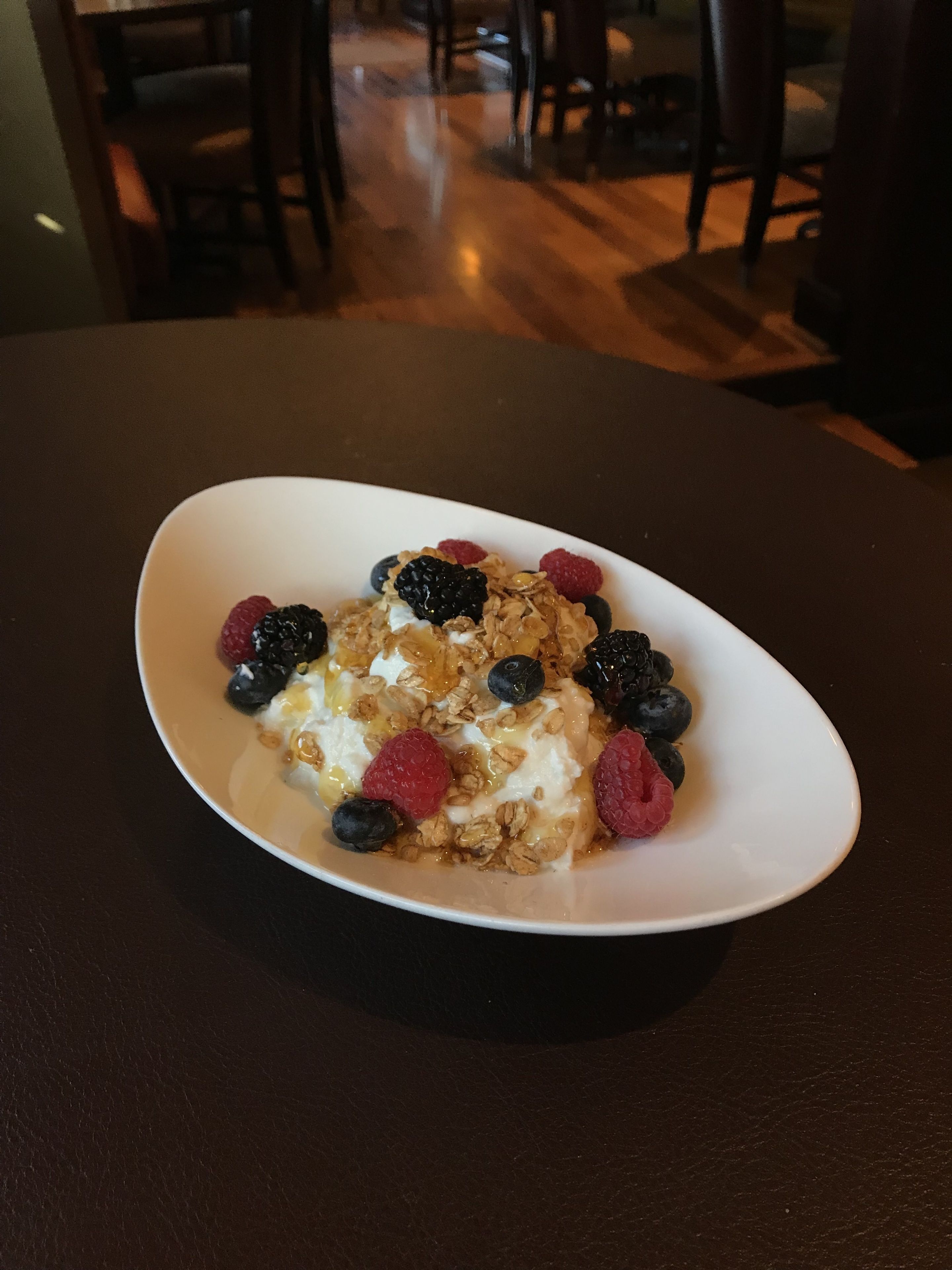 A white plate with a dessert on a dark table.