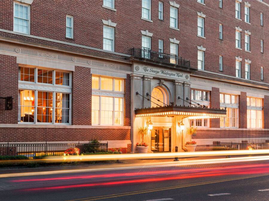 A brick building with large windows and a marquee entrance.