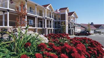 A multi-story hotel with balconies and a parking area.