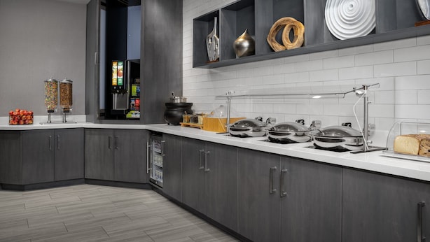 A modern kitchen with grey cabinets, a white countertop, and various kitchen appliances. - SpringHill Suites by Marriott Annapolis (Annapolis)