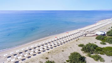 Privéstrand vlakbij, wit zand, ligstoelen aan het strand, parasols