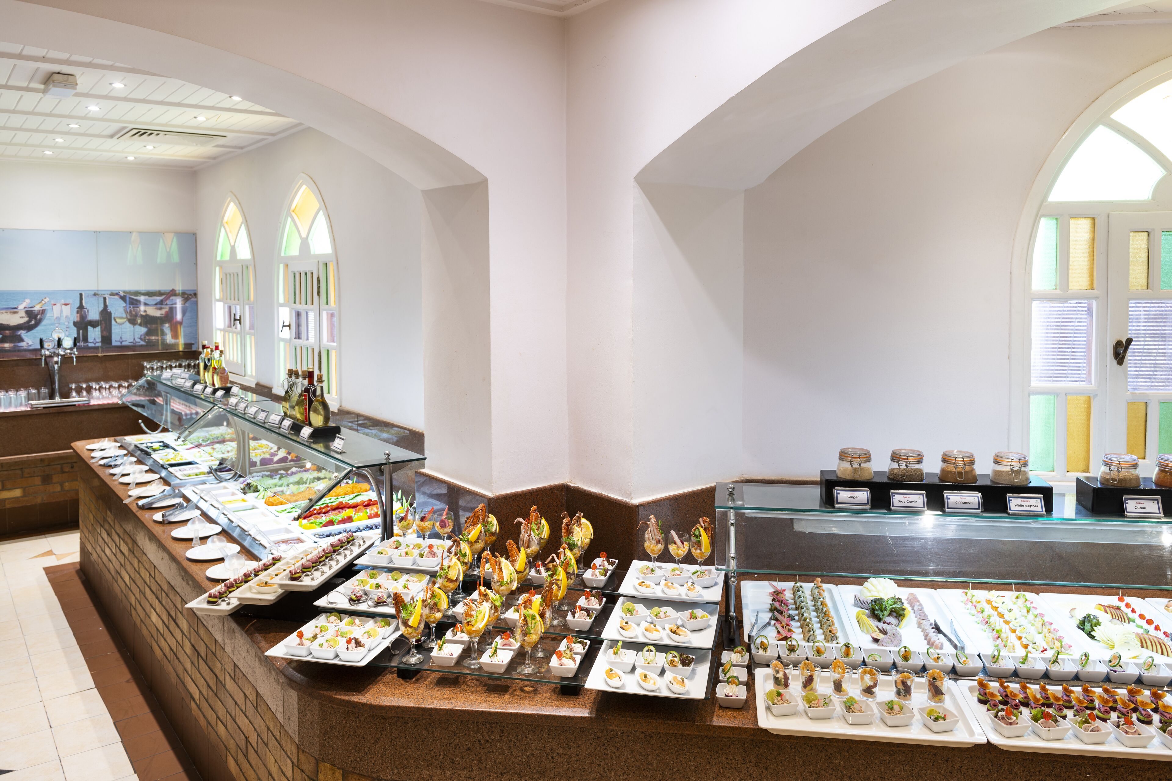 Un buffet proposant une variété de plats et une vitrine réfrigérée.