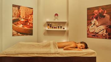 Experience a serene spa setting with a massage table, framed photographs, and soothing ambiance.