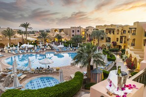 A resort with multiple swimming pools, lounge areas, and palm trees. - Three Corners Rihana Resort (El Gouna)