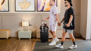 Two men in a hotel lobby with a lamp, a bench, and artwork on the wall. - The Purple Hotel by Ibiza Feeling - Adults only (Sant Antoni de Portmany)