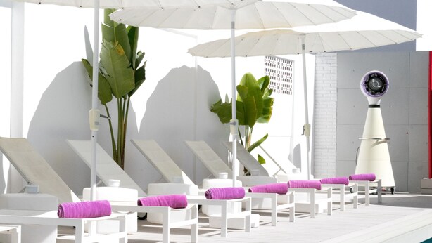 A poolside area with white lounge chairs, purple towels, and umbrellas. - The Purple Hotel by Ibiza Feeling - Adults only (Sant Antoni de Portmany)