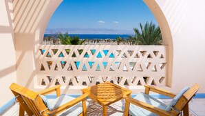 Un balcone con mobili in legno e vista sul mare.