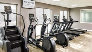 A gym with treadmills, ellipticals, and a stair climber, with a sign for 'Mercure Hotel Birmingham West'. - Mercure Birmingham West Hotel (West Bromwich)
