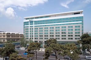 A modern hotel with a prominent "Radisson" sign, featuring a symmetrical facade with large windows and a flat roof. - Radisson Hotel Baku (Baku)