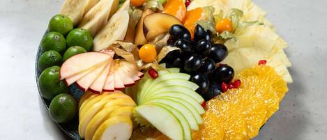 Una bandeja de frutas con diversas variedades, como manzanas, naranjas y uvas.
