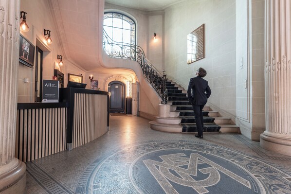A grand lobby with a marble floor, a staircase, and a reception desk. - Mercure Le Mans Centre (Le Mans)