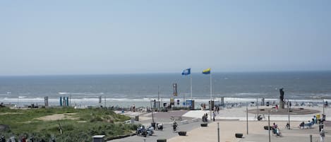 Un paseo marítimo con vistas al mar, bancos y una estatua.
