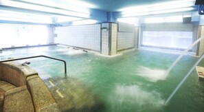 A large indoor pool with a wooden bench and a metal railing. - Prince Hotel (Jiaoxi)