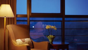 A room with a large window, a chair, a small table, and a lamp. - Kavalan Hotel (Luodong)