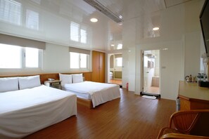 A hotel room with two beds, wooden flooring, a desk, and a chair. - The Lion Hotel (Luodong)
