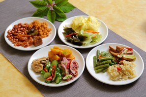 Four plates of food with various dishes including beans, meat, vegetables, and rice. - The Lion Hotel (Luodong)