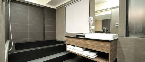 A modern bathroom with a large mirror, a sink, and a heated towel rail.