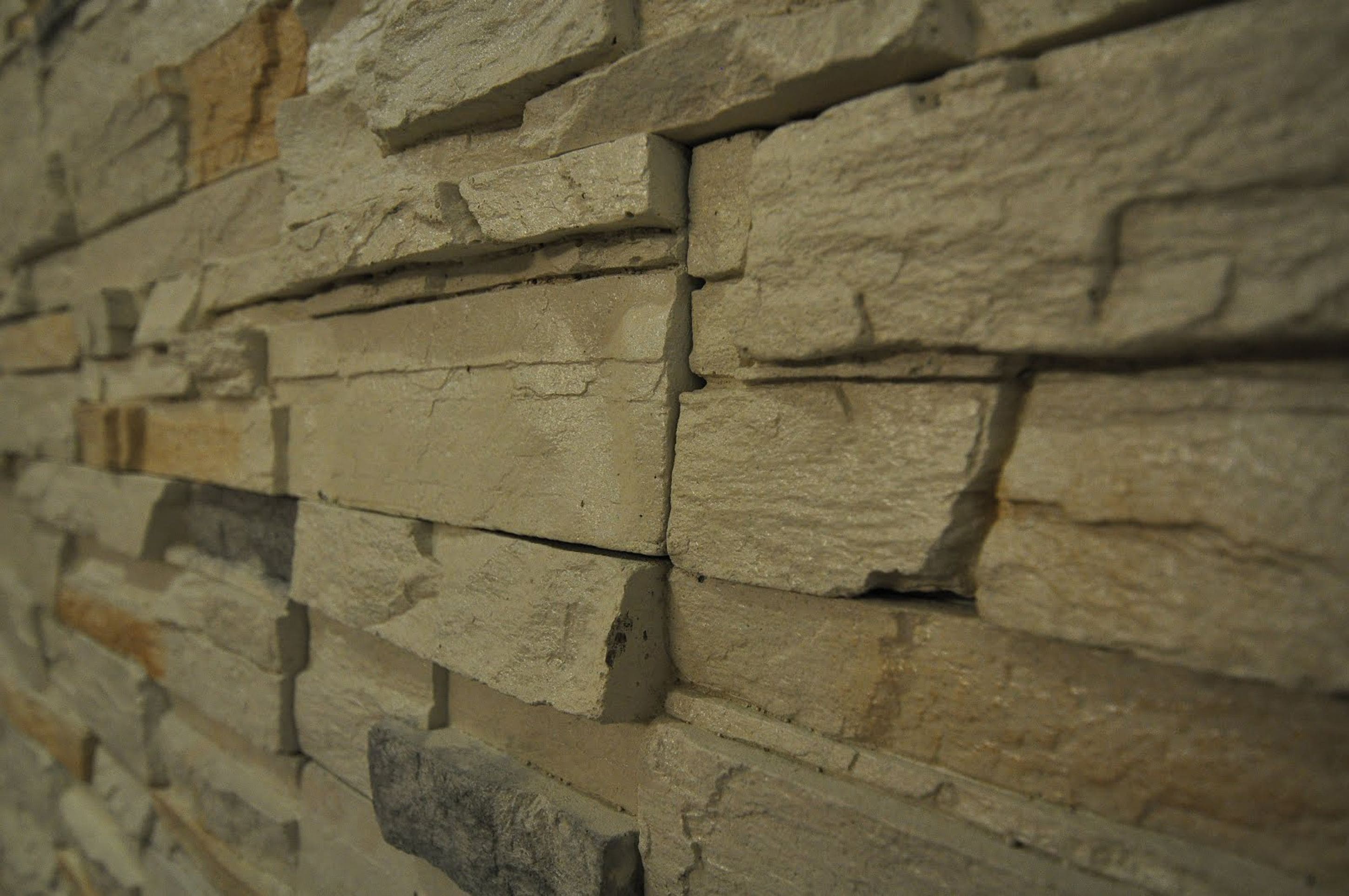 A close-up of a stone wall with irregularly shaped stones stacked horizontally.