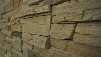 A close-up of a stone wall with irregularly shaped stones stacked horizontally.