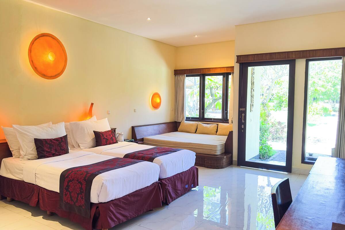 Habitación de hotel con dos camas, una lámpara de lava y vistas a zonas verdes.