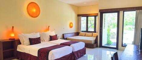 A hotel room with two beds, a lava lamp, and a view of greenery outside.