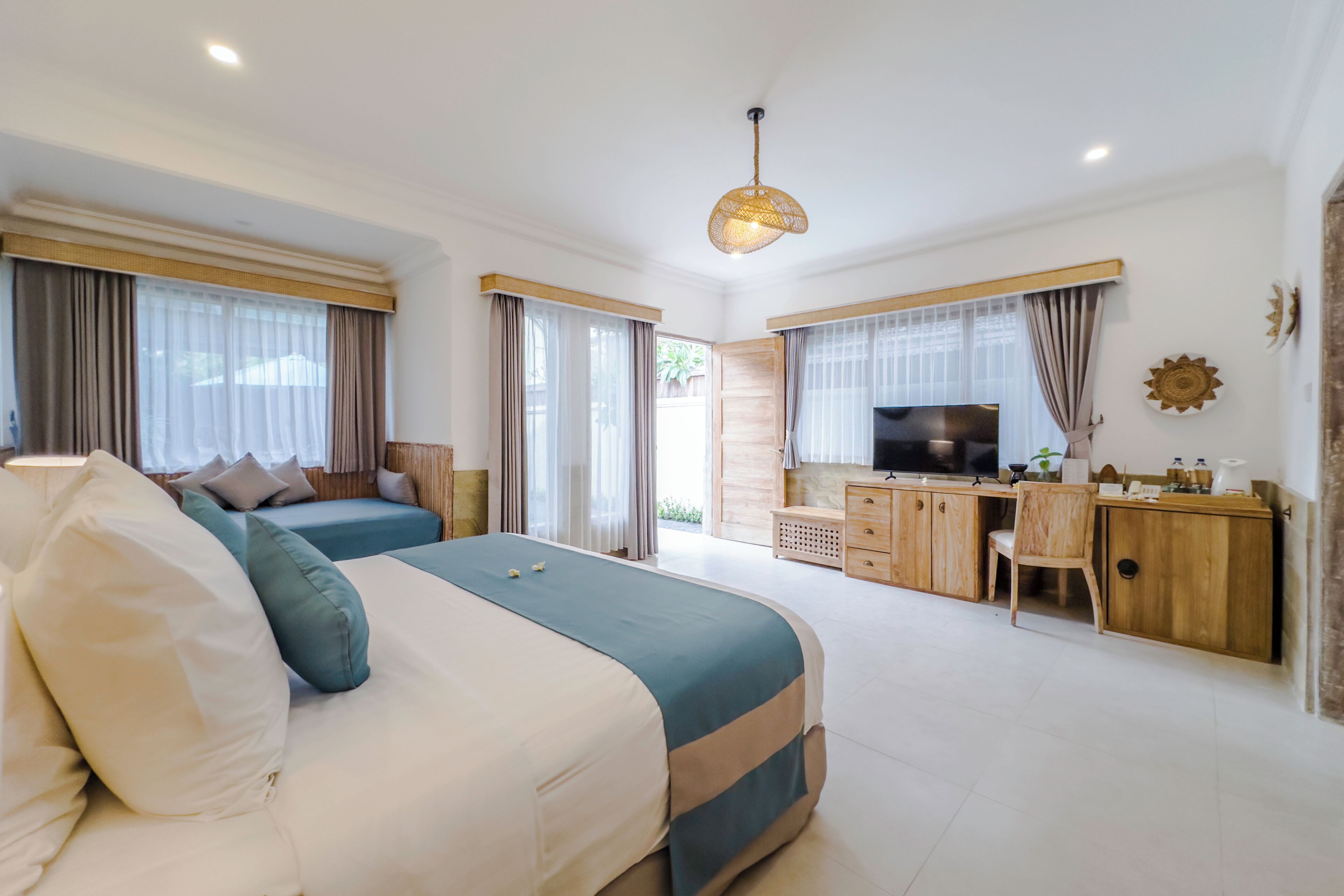 Habitación de hotel moderna con una cama grande, un escritorio y televisión.