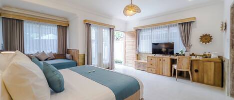 Habitación de hotel moderna con una cama grande, un escritorio y televisión.