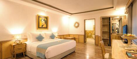Habitación de hotel con cama, mesitas de noche, escritorio y espejo.
