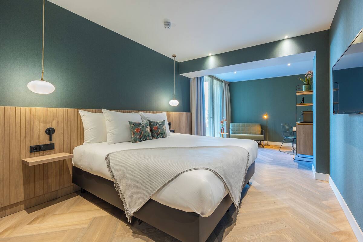 Ein modernes Schlafzimmer mit einem großen Bett, Holzwandverkleidung, einem Nachttisch und einem eingebauten Regal.