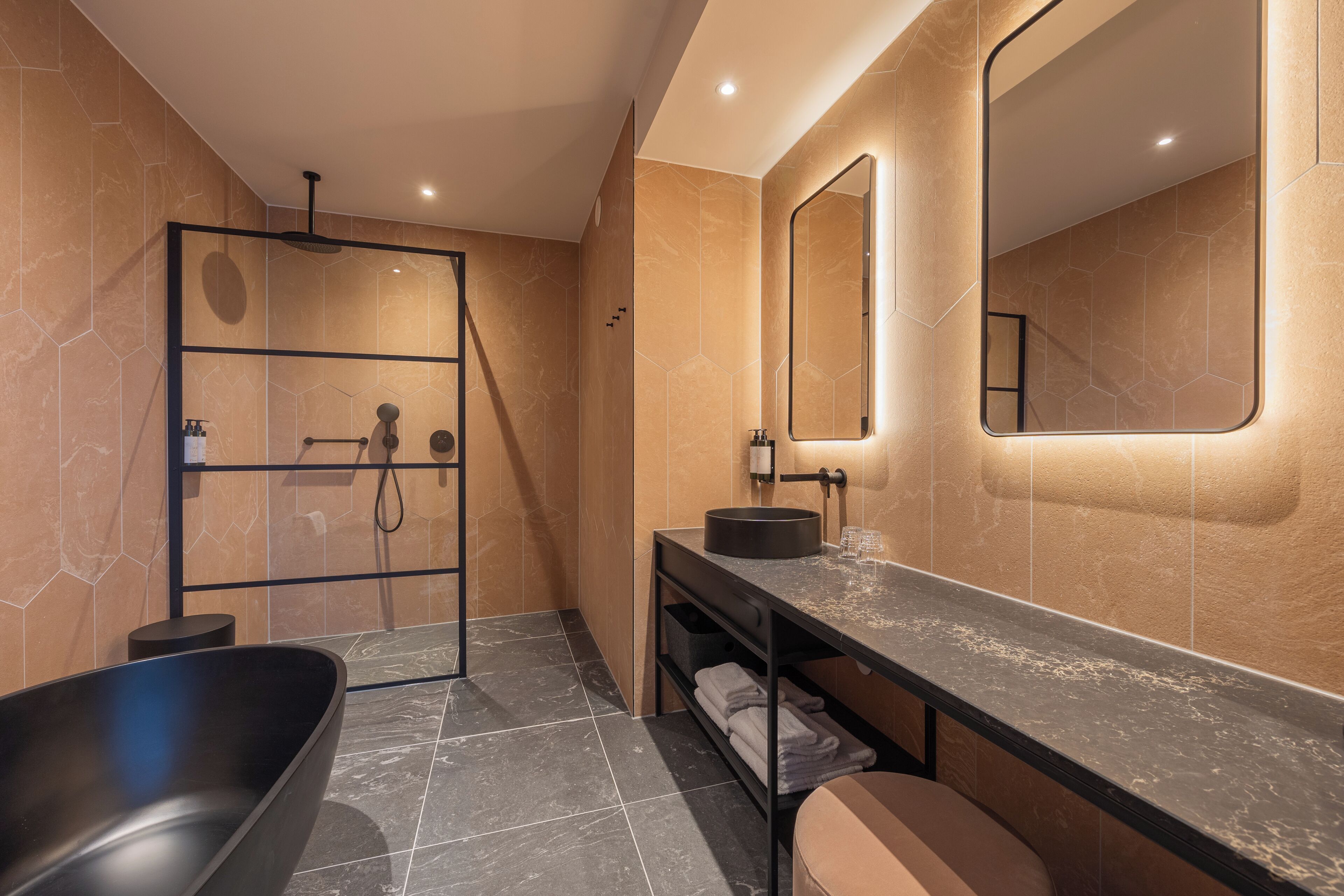 Un baño moderno con una bañera independiente, un tocador con espejo y un box de ducha.